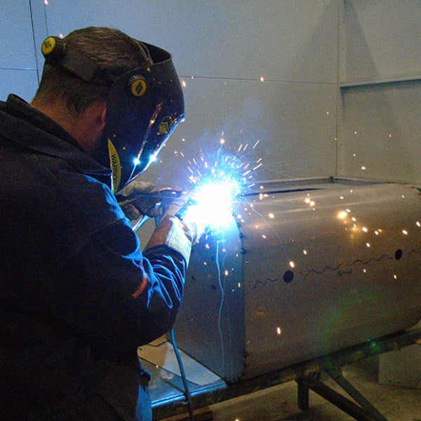 A welder fabricating a fireplace