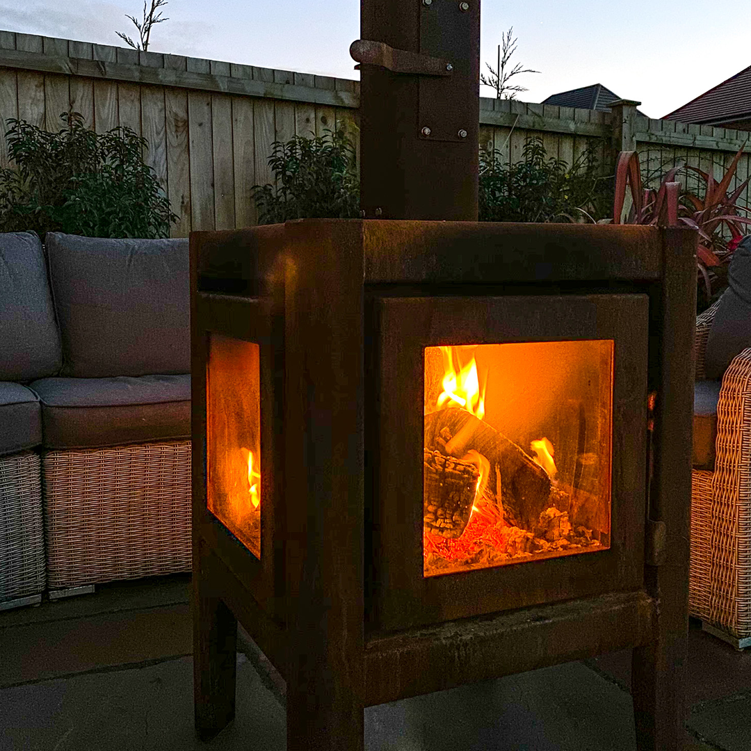 A lit L'Bode Cube Corten Edition Wood Burner